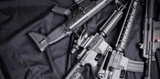 Assault rifles arranged on a black fabric background