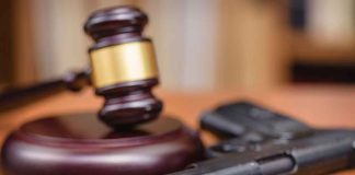 Gavel and handgun on a wooden surface