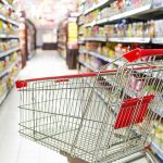 Empty shopping cart in grocery store aisle