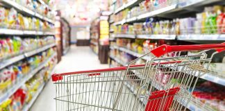 Empty shopping cart in grocery store aisle