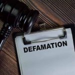 Gavel and clipboard with Defamation text