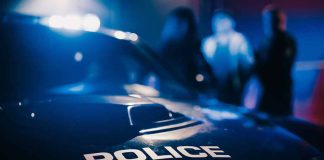 Police car with blurred figures in the background