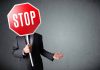 Person holding a stop sign over their face