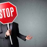 Person holding a stop sign over their face