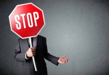 Person holding a stop sign over their face