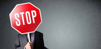 Person holding a stop sign over their face