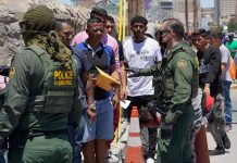 Border patrol agents inspecting group of individuals in line