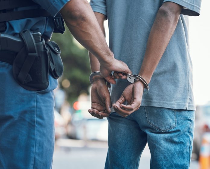 2337392319 featured image Police officer handcuffing person wearing blue clothes