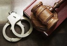 Handcuffs beside a gavel on a book