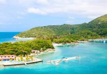 Tropical beach with docks and lush green hills