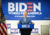 Man at podium with Biden campaign signs behind him