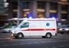 Ambulance driving on urban street with lights flashing
