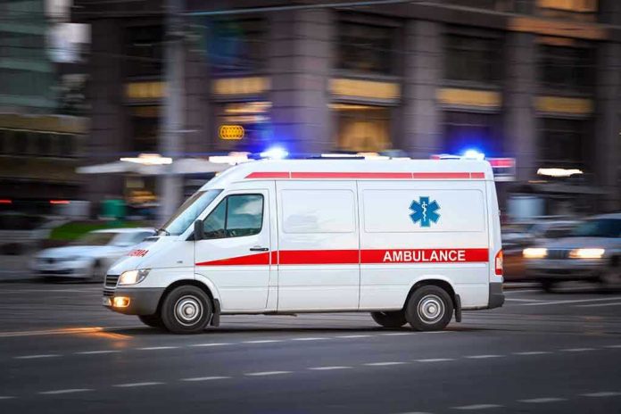 2002660841 Ambulance driving on urban street with lights flashing