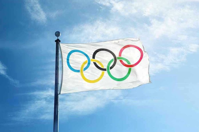 328195181 Olympic flag waving against a clear blue sky