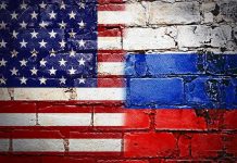 United States and Russian flags painted on brick wall