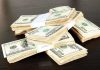 Stacks of bundled cash on a wooden table
