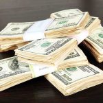 Stacks of bundled cash on a wooden table
