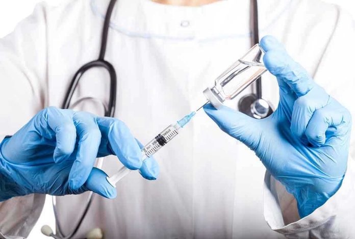 1310971853 Doctor filling syringe with vaccine from vial