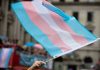 Transgender flag waving in a crowded street.