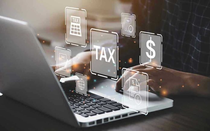 2018230646 Person typing on laptop with tax-related icons displayed.