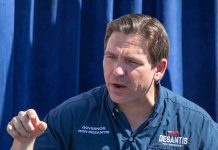 Man in "Desantis for President" shirt speaking.