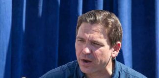 Man in "Desantis for President" shirt speaking.