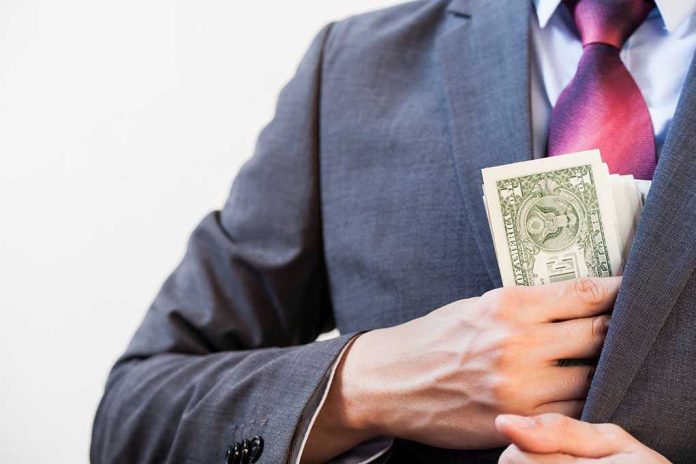 394112617. Person in suit putting dollars in jacket pocket.