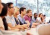 A diverse group of students attentively listening in a classroom setting