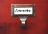 MILLENNIALS FIGHT BACK: Financial Secrets Exposed! Metal label holder saying Secrets on wood background
