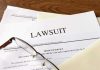 Documents labeled Lawsuit with glasses on top