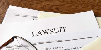 Documents labeled Lawsuit with glasses on top