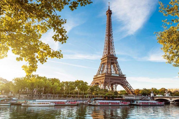 Eiffel Tower in Paris with boats on the river and green trees