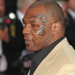 Profile of a man with a facial tattoo at a red carpet event
