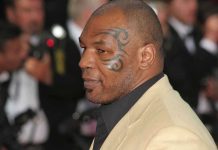 Profile of a man with a facial tattoo at a red carpet event
