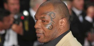 Profile of a man with a facial tattoo at a red carpet event