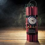 A stick of dynamite with a clock timer and wires, set against a dark smoky background