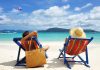 A couple relaxing on colorful beach chairs by the ocean