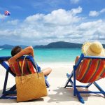 A couple relaxing on colorful beach chairs by the ocean
