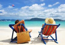 A couple relaxing on colorful beach chairs by the ocean