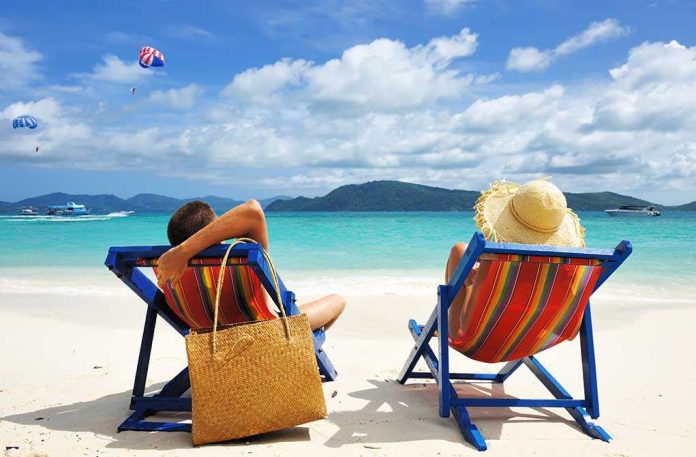 A couple relaxing on colorful beach chairs by the ocean