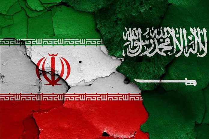 Cracked flags of Iran and Saudi Arabia.