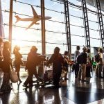 Airport Grounds ALL Flights — Runway in Chaos! Crowd of travelers in airport terminal with airplane outside.