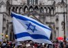 Israel Soccer Match POSTPONED—Tel Aviv Fans RUN WILD! Israeli flag at a crowded outdoor event.