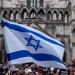 Israel Soccer Match POSTPONED—Tel Aviv Fans RUN WILD! Israeli flag at a crowded outdoor event.