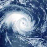 Million FLEE As Killer Storm Strikes – CATASTROPHE! Satellite image of a swirling hurricane over ocean.