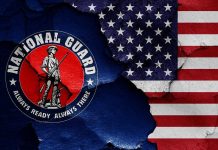 National Guard Members SHOT – IMMEDIATELY Blame Game Starts National Guard logo over a distressed American flag.