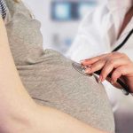Woman Suffers Miscarriage – Felony Charge Follows? Doctor uses stethoscope on pregnant womans belly.