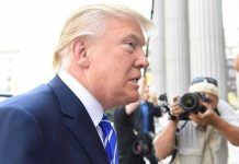 TRUMP DEFIES Judge—Millions Left Hanging Man in suit with photographers in background.