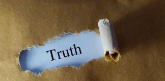 Ripped paper reveals word truth underneath brown surface