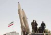Missile Parade SHOCK—Iran Defies the World Military personnel beside missiles and Iranian flag.